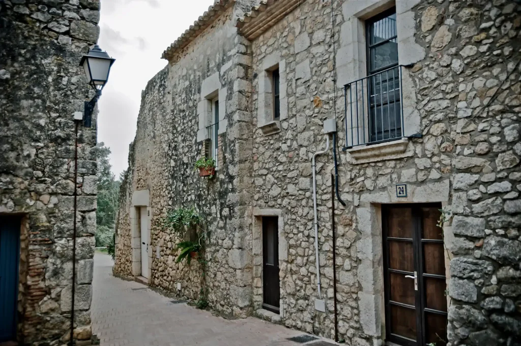 Calle empedrada con casas de piedra en las ruinas de Empúries, Costa Brava