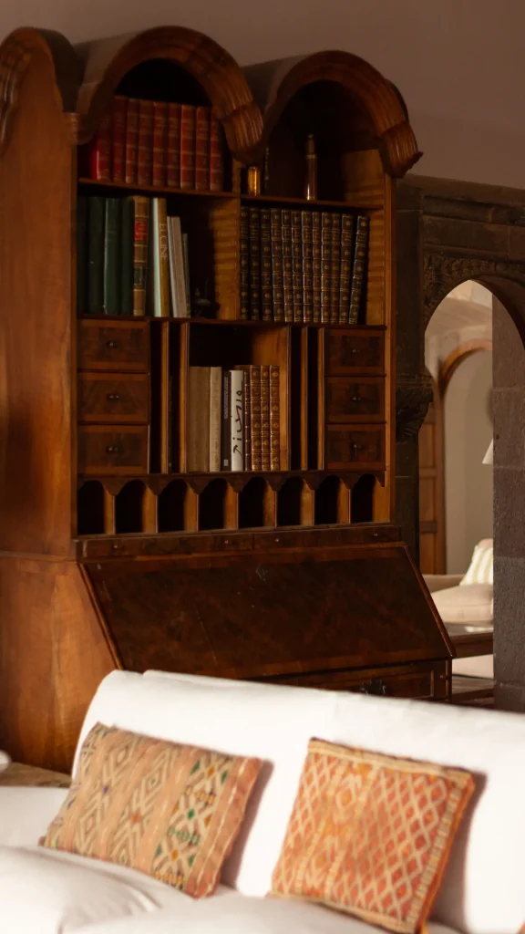 Zona de lectura con estantería antigua y cojines en el Castell de Sant Mori