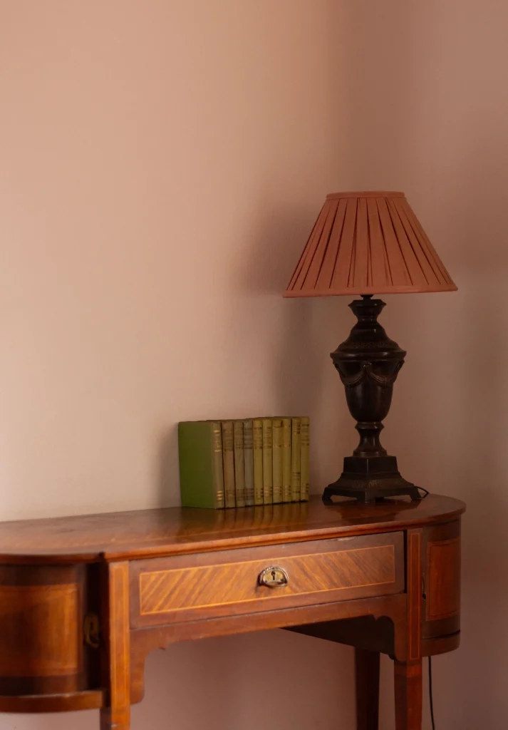Lámpara de mesa clásica sobre consola de madera en habitación del Castell de Sant Mori