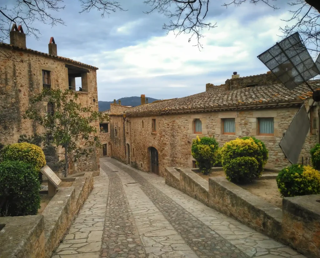 Calle empedrada con casas de piedra en el pueblo medieval de Pals