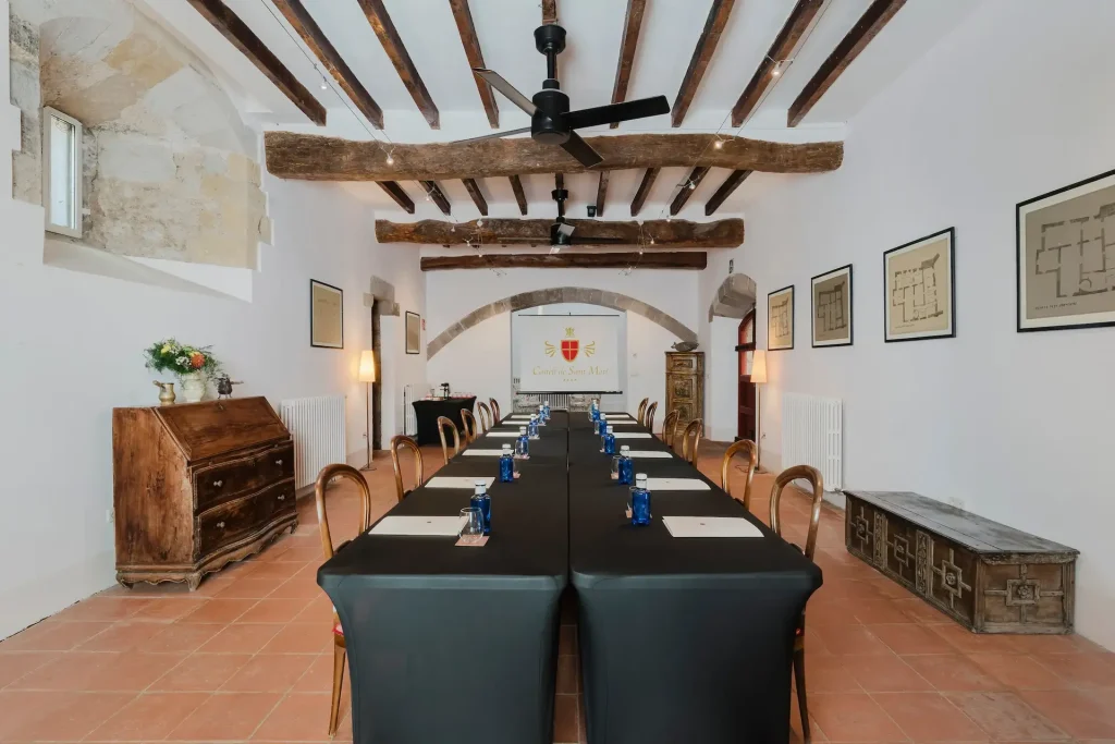 Sala d’estar amb sostre de fusta i parets de pedra