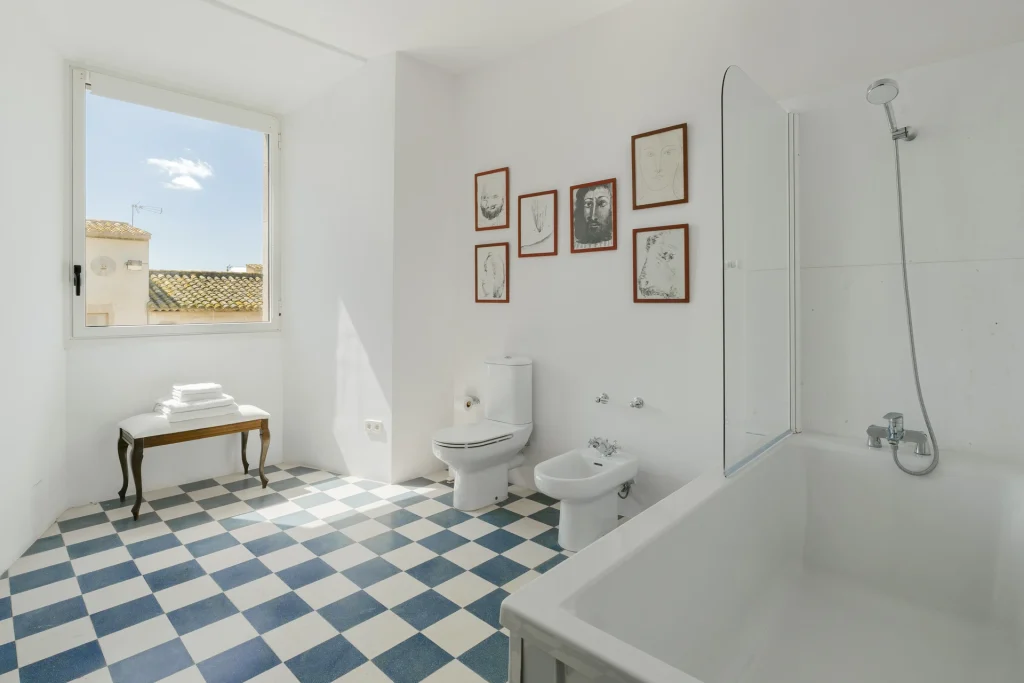 Baño con bañera y cuadros decorativos