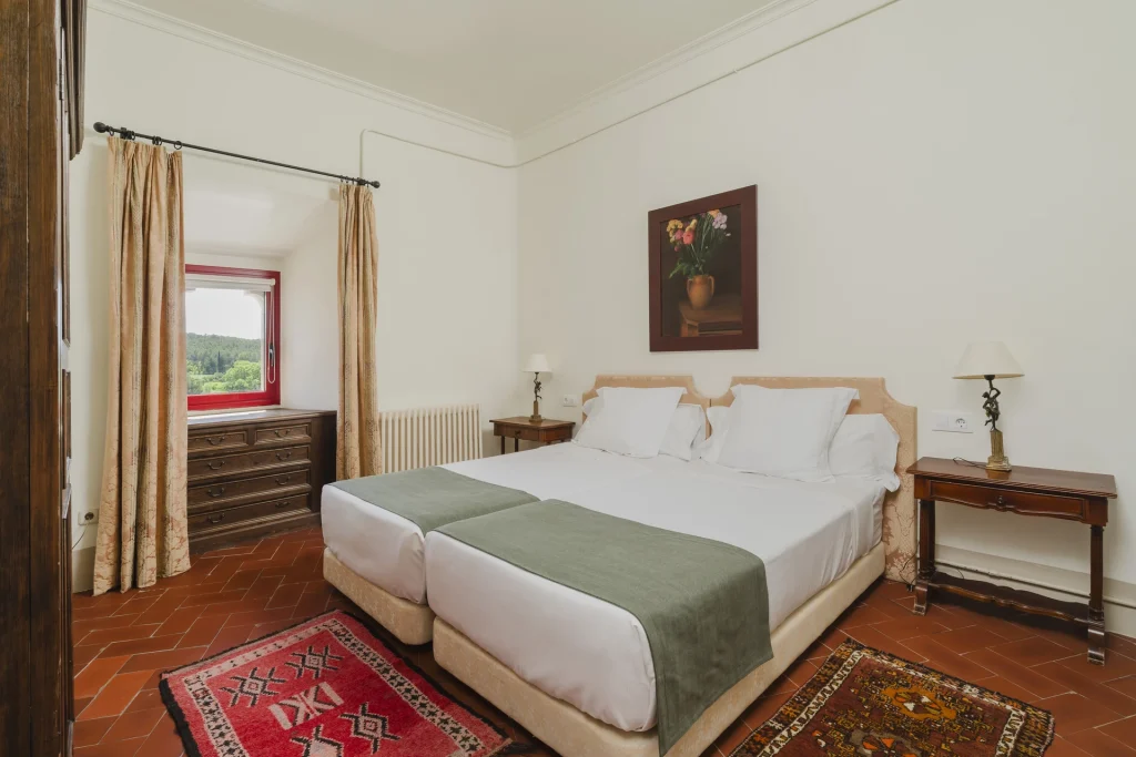 Dormitorio con cama doble y mesitas clásicas
