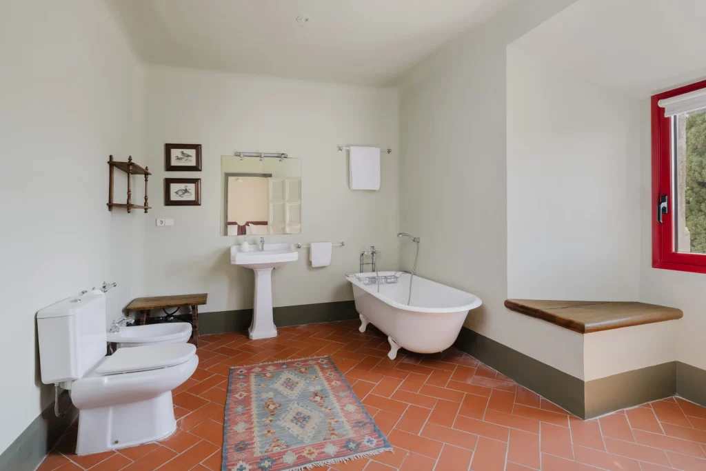 Baño espacioso con doble lavabo y alfombra