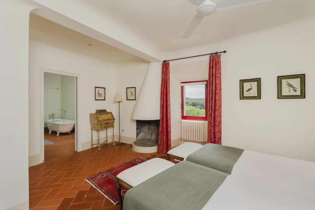 Dormitorio doble con cortinas rojas y paredes crema