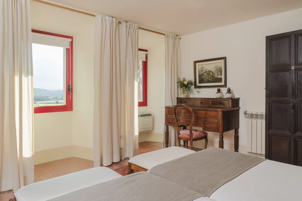Dormitorio con cama doble y cortinas claras