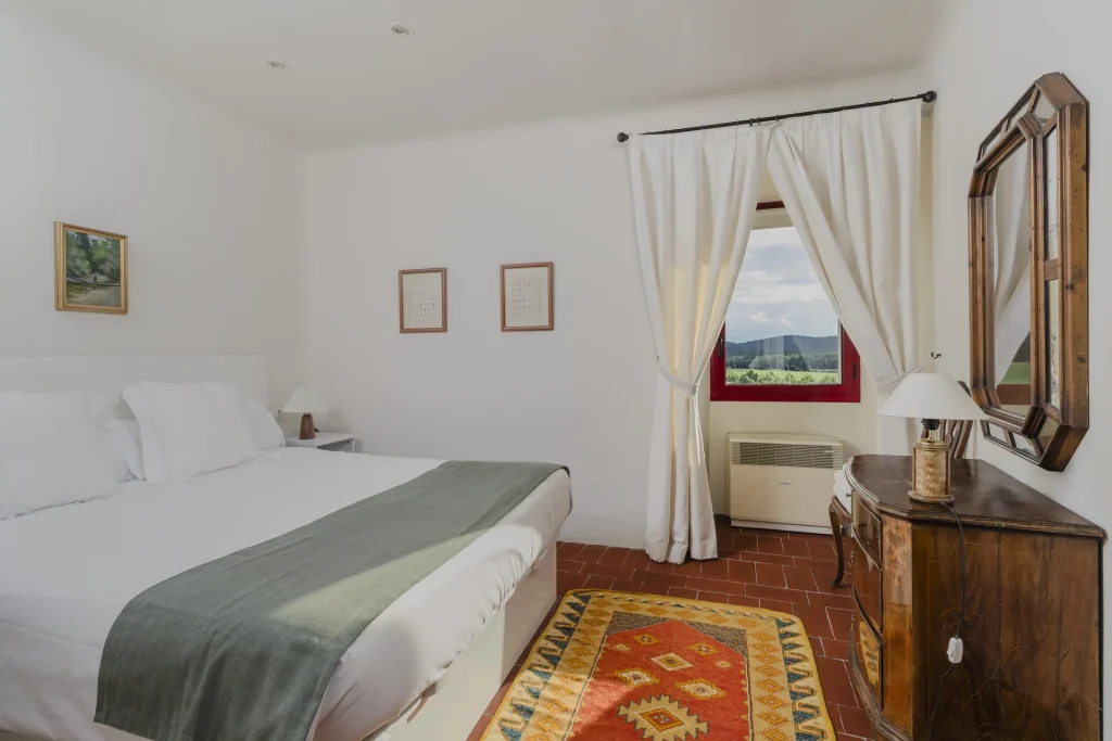 Habitación con cama doble y tocador antiguo