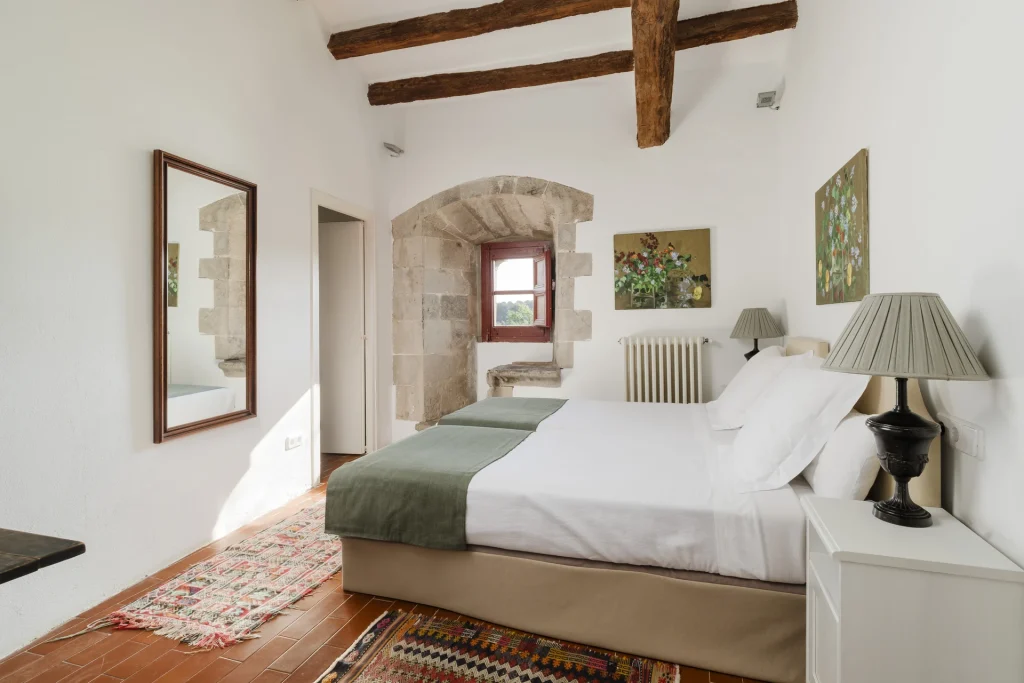 Dormitorio con cama doble y pared de piedra