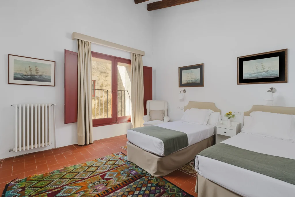 Dormitorio con dos camas y balcón exterior
