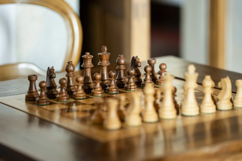 Ajedrez de madera sobre mesa antigua.