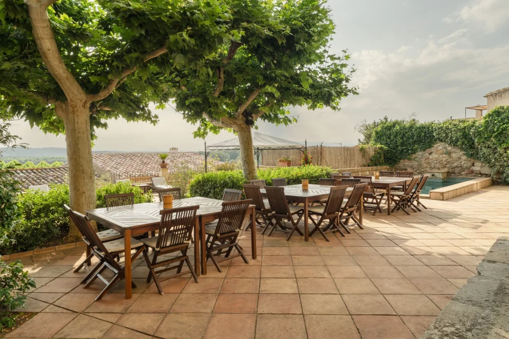 Terraza con mesas bajo la sombra.